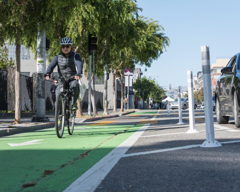 A man riding a bike on the parking-protected bikeway on Folsom Street