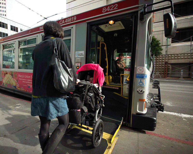 woman with child in stroller boards muni bus using ramp