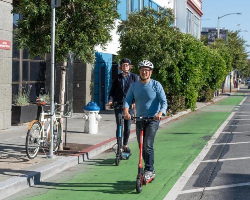 People riding scooters in green bike lane