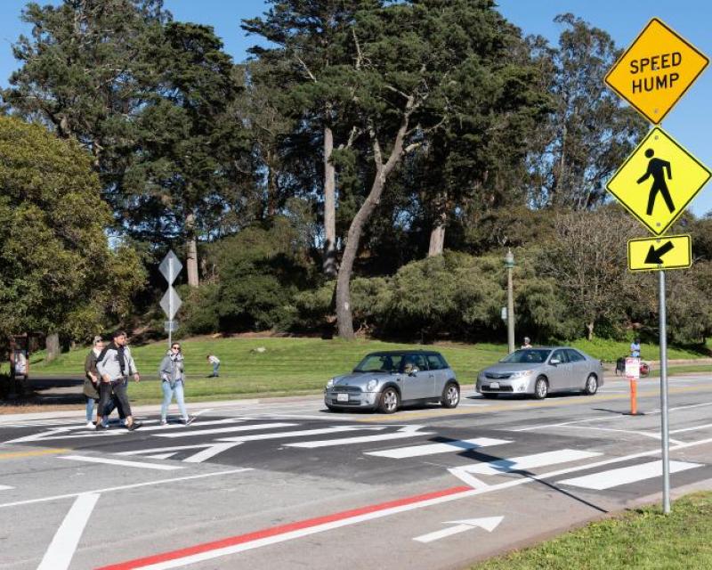 People walking across the street on a a raised crosswalk