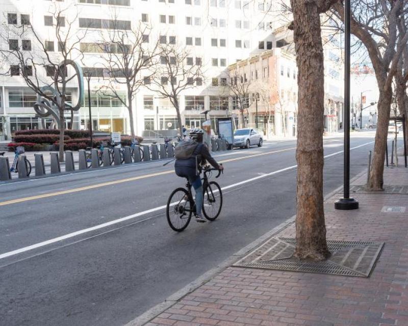 Image shows person biking down empty San Francisco street