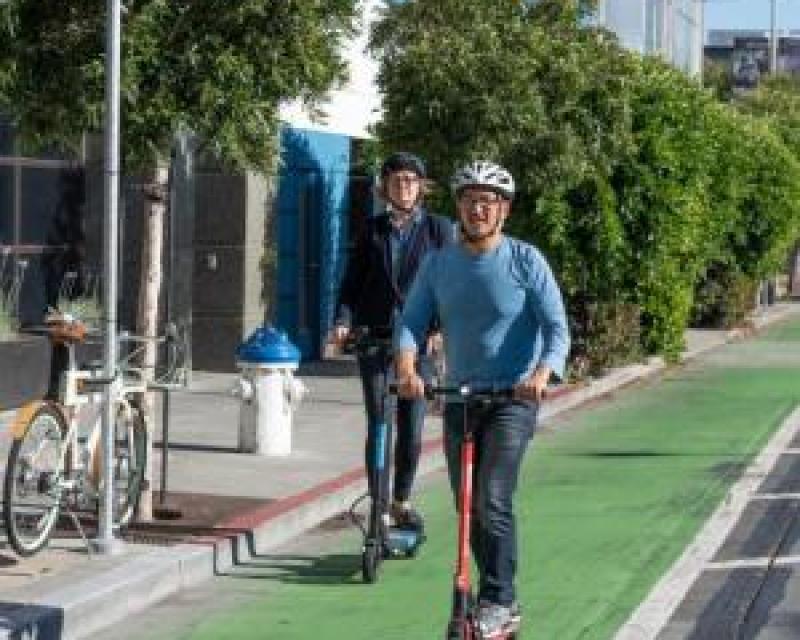 People riding scooters in green bike lane
