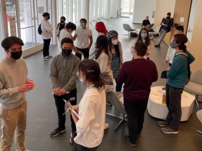 Group of youth standing in a conference room engaged in conversation with each other. 