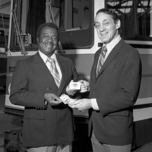 Black and white photo of Curtis Green and Harvey Milk standing in front of a streetcar.