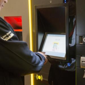 A man uses a touch screen for the new parking garage payment system.