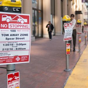 row of parking meters with no stopping temporary event signs