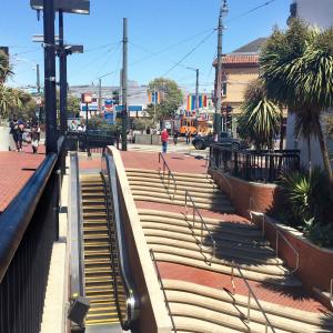 People walking around Harvey Milk Plaza and Castro Station entrance