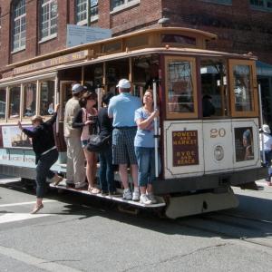 cable car with people on board stopped in intersection to unload