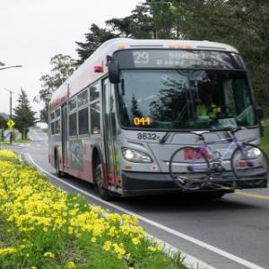 Hybrid bus rides through city street