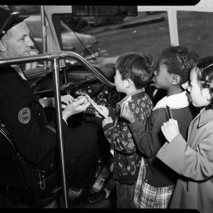 Bus driver greets children in historic photo