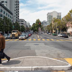 A pedestrian crosses the street at Golden Gate Avenue and Van Ness Avenue
