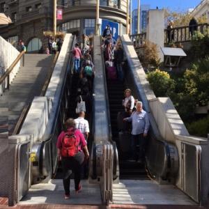 Image of people coming down a muni metro escalator at Hallidie Plaza