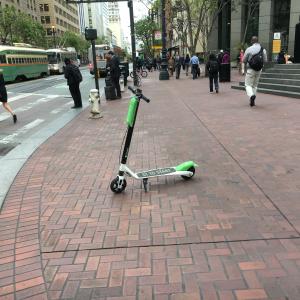 A Lime scooter parked on a Market St. sidewalk