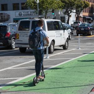 Man rides shared, powered scooter in bike lane