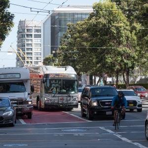 30 Stockton bus traveling north on Third Street. Driving in the red transit lane, the bus is blocked by vehicles turning right.