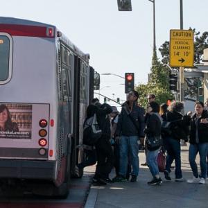 People boarding a 43 Fort Mason coach at Balboa Park.