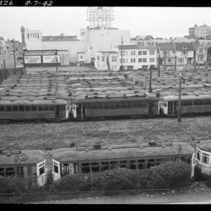 derelict streetcars sit in a large empty lot