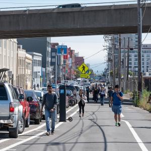 People walking under the freeway in the afternoon