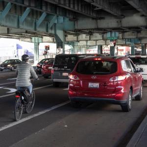 A bicyclist rides in mixed traffic on 13th Street