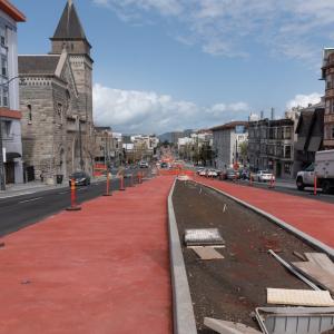 Photo of red concrete freshly poured on Van Ness Avenue which will serve as transit lanes for the bus rapid transit system