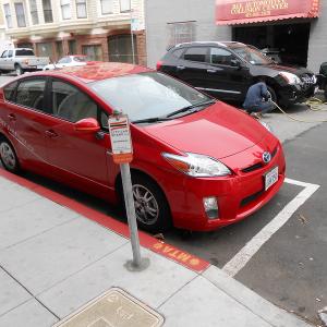 A shared vehicle parked at a permitted car share only curbside parking space.