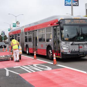 Photo of crew striping red paint on Geary Boulevard