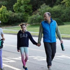 Photo of man holding child's hand while they walk in Golden Gate Park