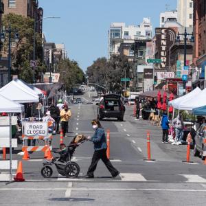 Photo of a street closed in the Tenderloin during summer 2021 with vendors and pedestrians