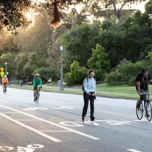 People jogging, biking, and skating on the JFK Drive Promenade