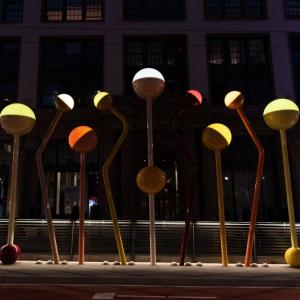 A light sculpture of colorful round orbs of light on bent and angled colored poles installed at Van Ness and O’Farrell streets