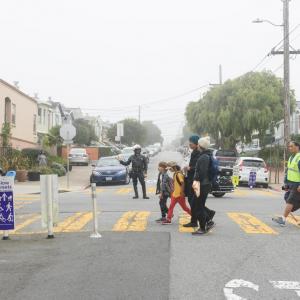 Children cross Slow Hearst on their way to school.