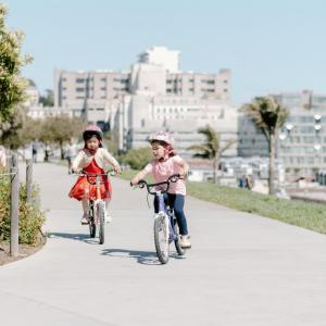 Young bicyclist with helmets and smiles in motion on their bicycles 