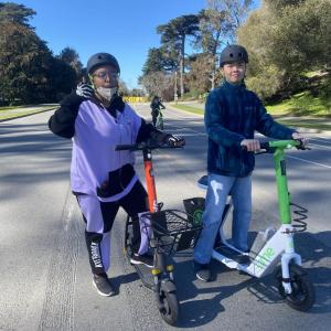 AccessSFUSD students standing with Lime and Spin scooters; one student is giving a thumbs up