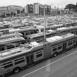 a high-angel view of a crowded bus yard, packed with trolley buses