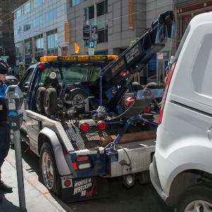 Tow truck towing vehicle Parking Control officer present 