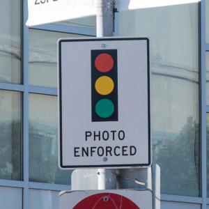 Traffic sign with an image of a traffic signal and the words photo enforced
