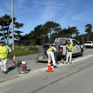 A group of men in safety vests on a road
