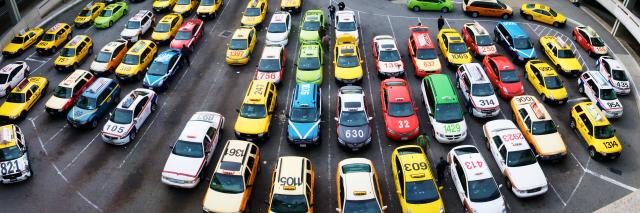overhead view of taxi cabs in parking lot of SFO airport showing many different cars and company liveries