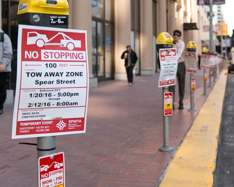 row of parking meters with temporary no stopping signs affixed to them