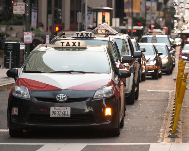 line of taxicabs waiting for traffic light on California Street