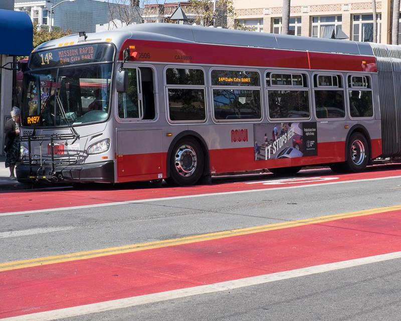 Muni bus with advertisement on Mission Street.