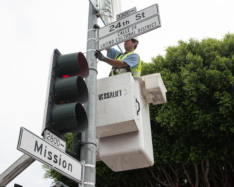 man in bucket truck installing street sign