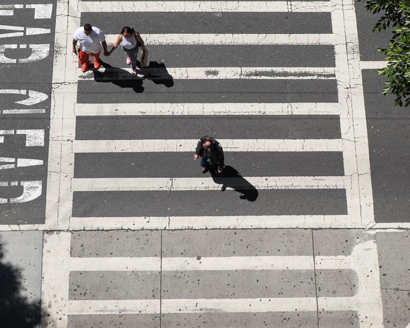 overhead view of striped crosswalk with people crossing