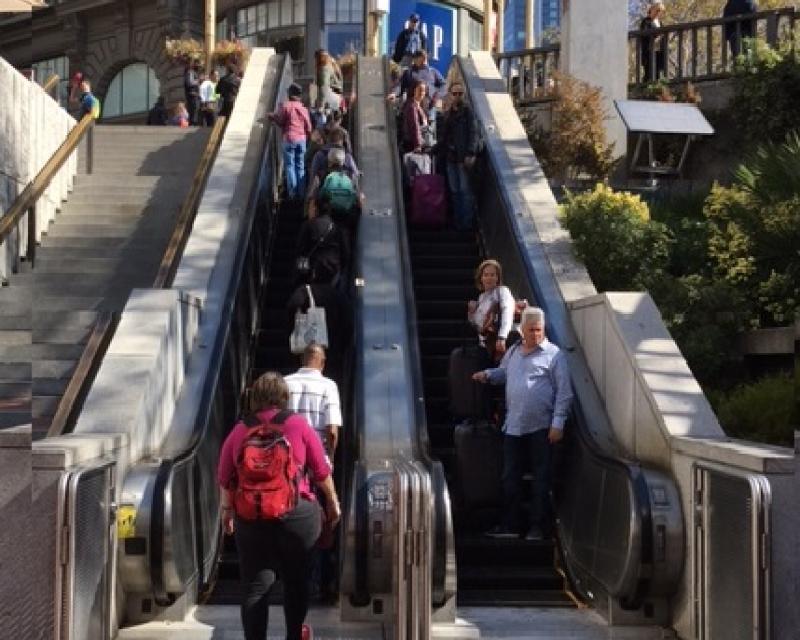Image of people coming down a muni metro escalator at Hallidie Plaza